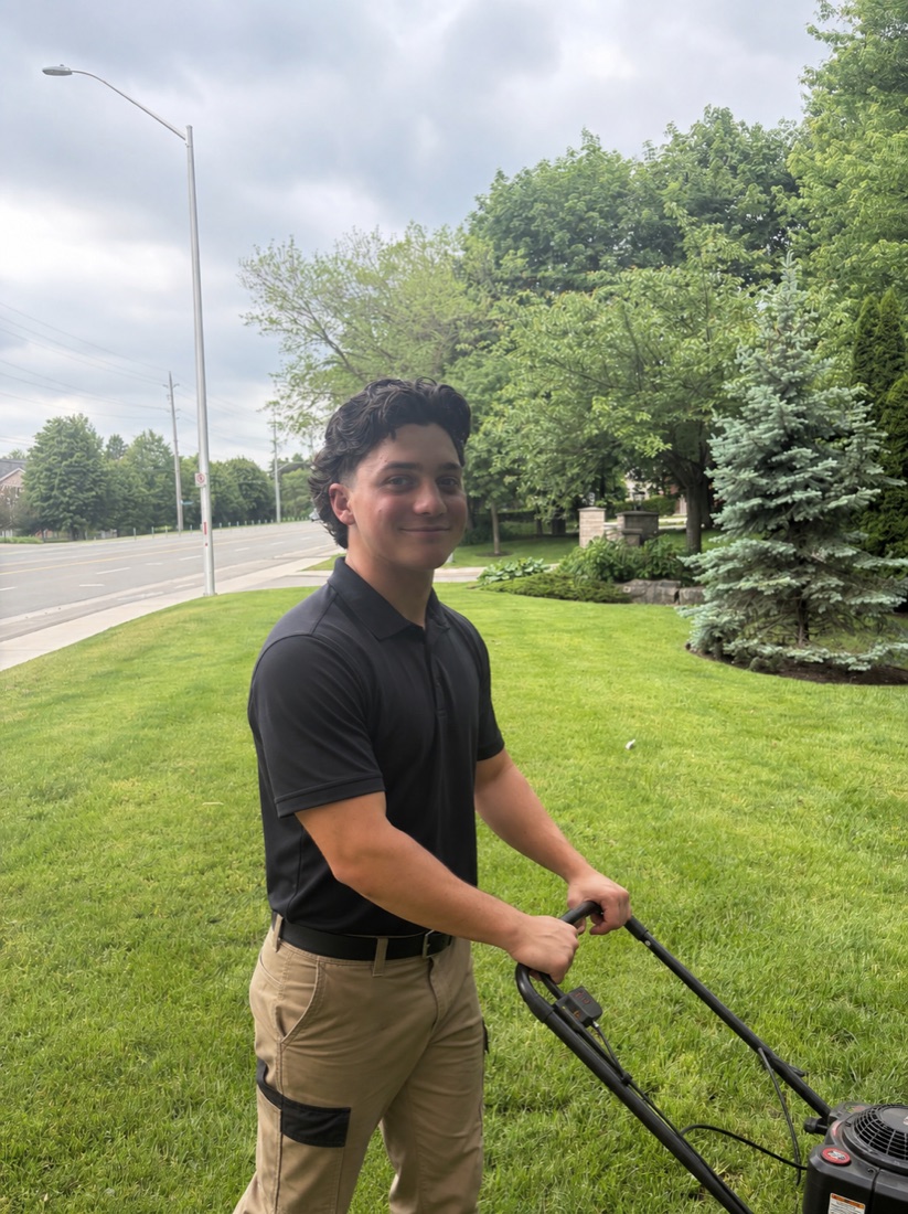 Oliver, founder of Aldershot Cut Co., mowing a lawn in Aldershot, Burlington